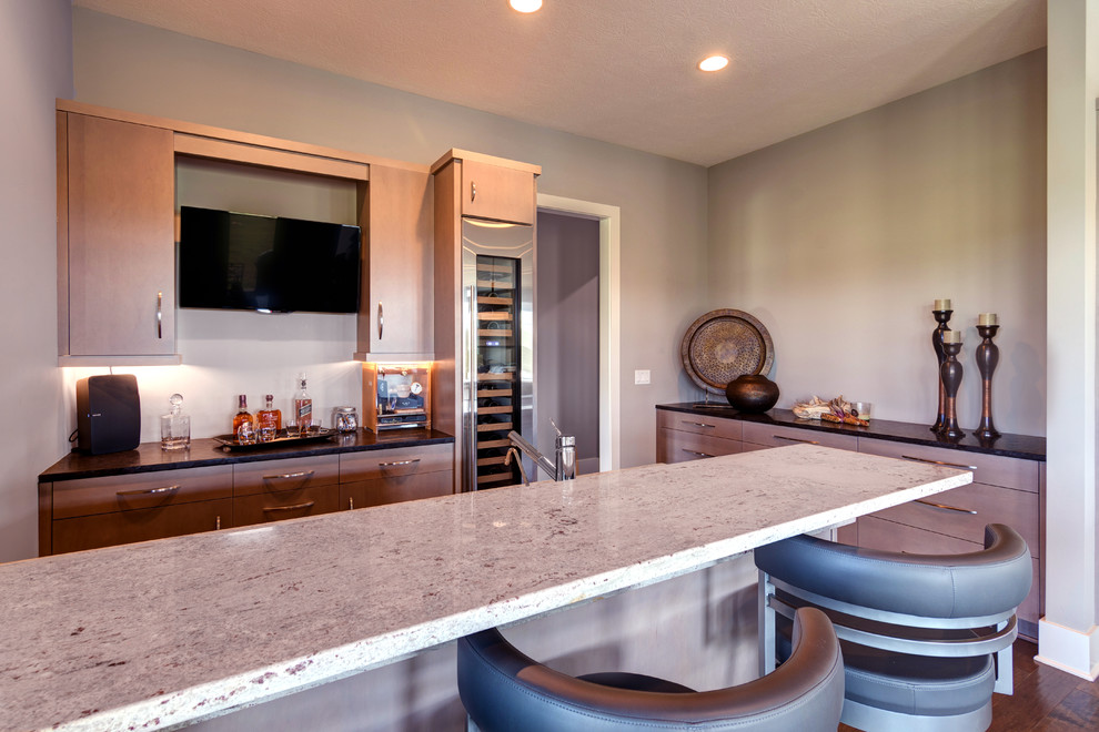 Photo of a medium sized contemporary galley breakfast bar in Indianapolis with a submerged sink, flat-panel cabinets, light wood cabinets, engineered stone countertops, dark hardwood flooring and brown floors.