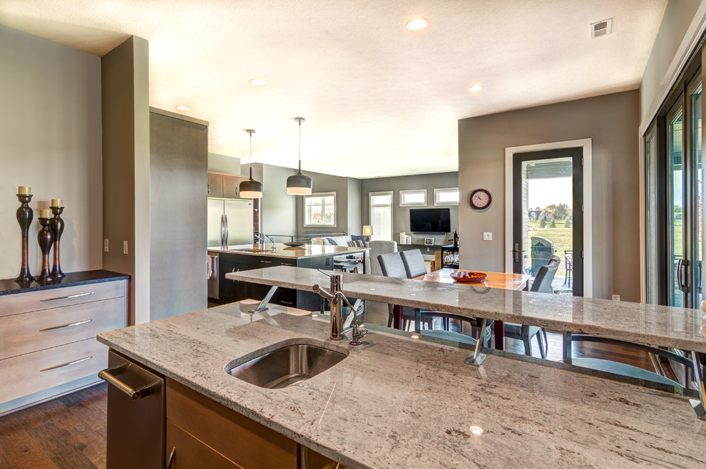This is an example of a medium sized contemporary galley breakfast bar in Indianapolis with a submerged sink, flat-panel cabinets, light wood cabinets, engineered stone countertops, dark hardwood flooring and brown floors.