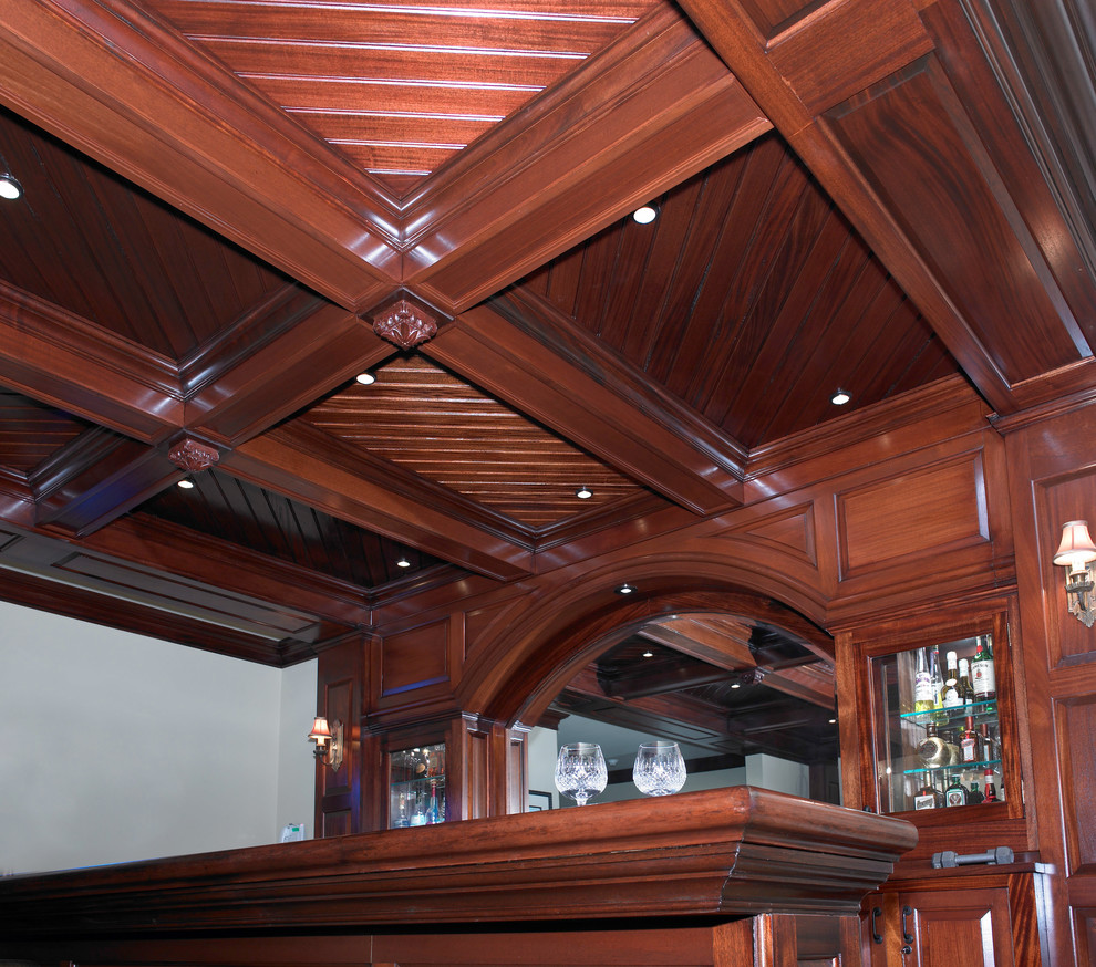Immagine di un bancone bar classico con ante in legno bruno e top in marmo