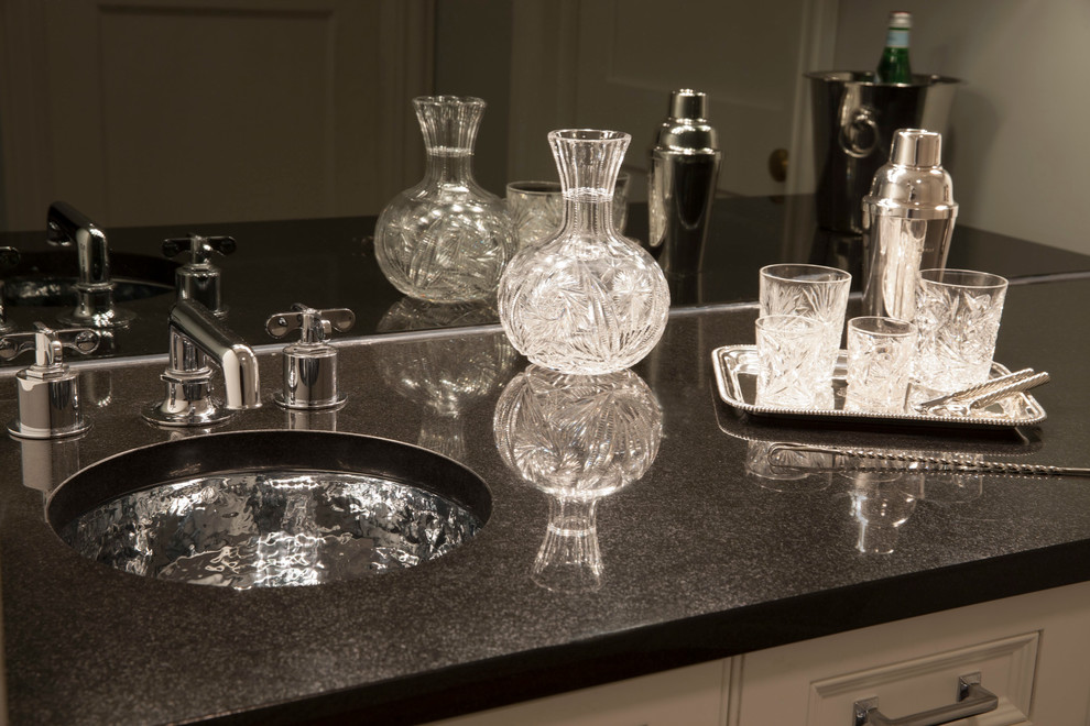 This is an example of a medium sized traditional single-wall wet bar in Chicago with a submerged sink, glass-front cabinets and white cabinets.