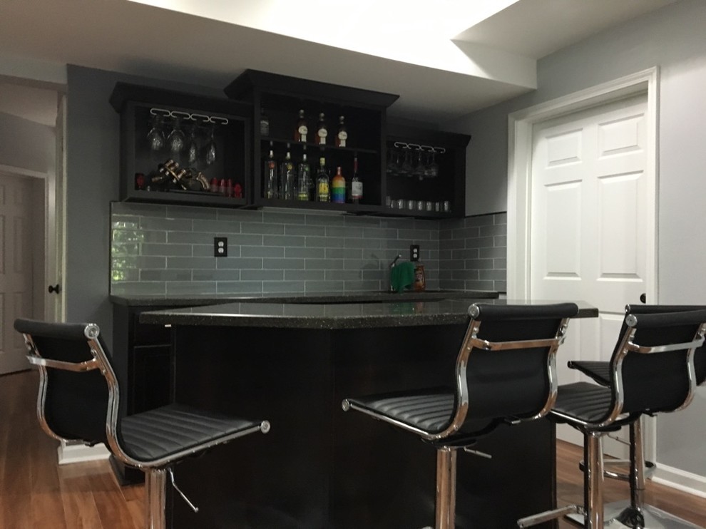 Wet bar - small traditional galley laminate floor and beige floor wet bar idea in Atlanta with an undermount sink, shaker cabinets, dark wood cabinets, solid surface countertops, gray backsplash and glass tile backsplash