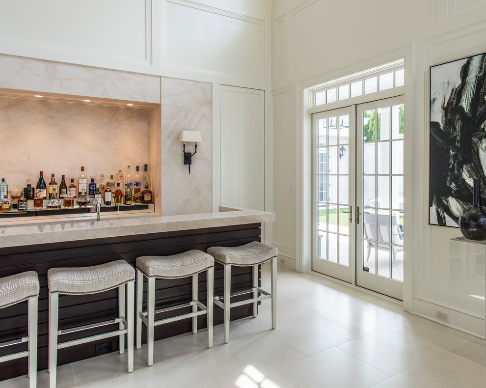 Exemple d'un grand bar de salon avec évier chic avec un évier encastré, plan de travail en marbre, une crédence beige et une crédence en dalle de pierre.