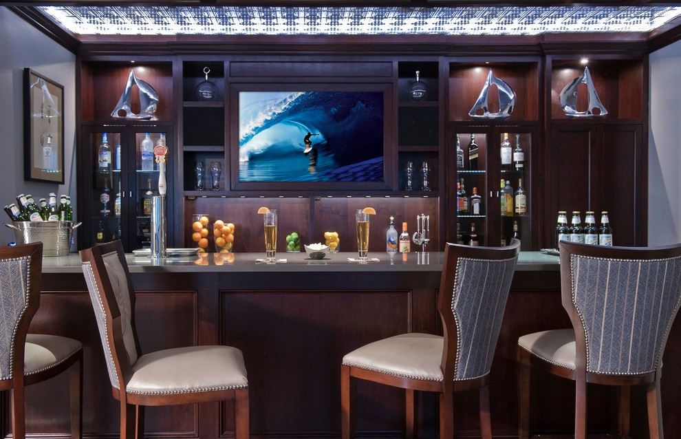 Diseño de bar en casa con barra de bar clásico grande con armarios tipo vitrina, puertas de armario de madera en tonos medios y encimera de cuarzo compacto