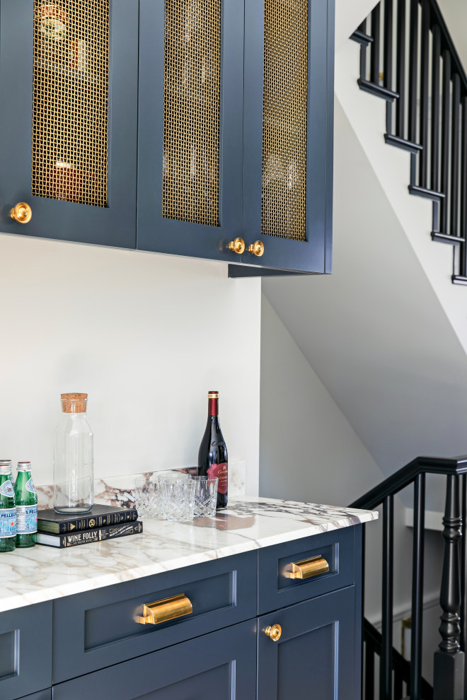 Small classic single-wall home bar in Calgary with shaker cabinets, blue cabinets, marble worktops, white splashback, light hardwood flooring and multicoloured worktops.