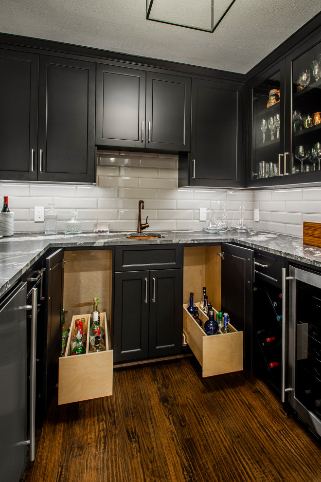 Design ideas for a medium sized traditional single-wall wet bar in Dallas with a built-in sink, recessed-panel cabinets, black cabinets, engineered stone countertops, white splashback, ceramic splashback, dark hardwood flooring, brown floors and grey worktops.