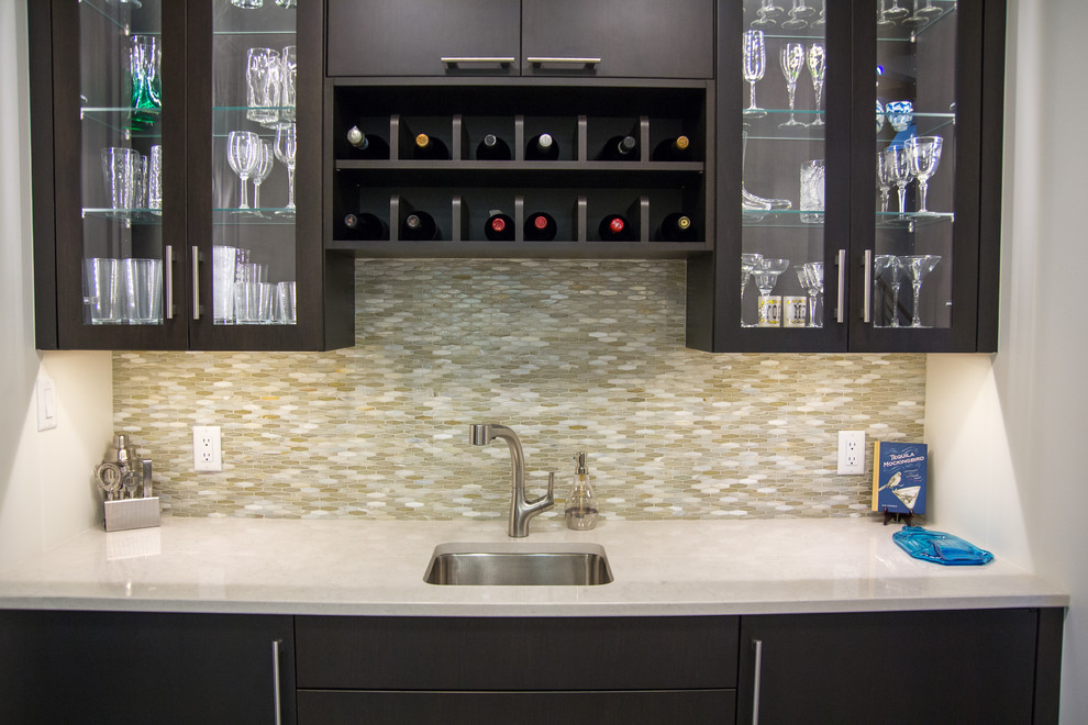 Photo of a small contemporary single-wall wet bar in DC Metro with a submerged sink, flat-panel cabinets, dark wood cabinets, engineered stone countertops, multi-coloured splashback, glass sheet splashback, porcelain flooring, grey floors and white worktops.