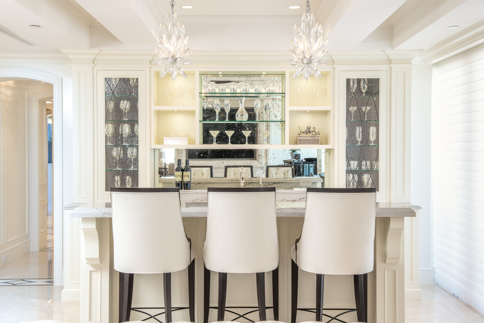 Idee per un bancone bar stile marino con ante di vetro, ante bianche, top in marmo, paraspruzzi a specchio, top bianco e pavimento multicolore