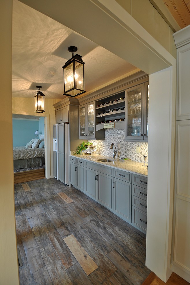 Inspiration for a coastal home bar remodel in Nashville with recessed-panel cabinets, green cabinets and granite countertops