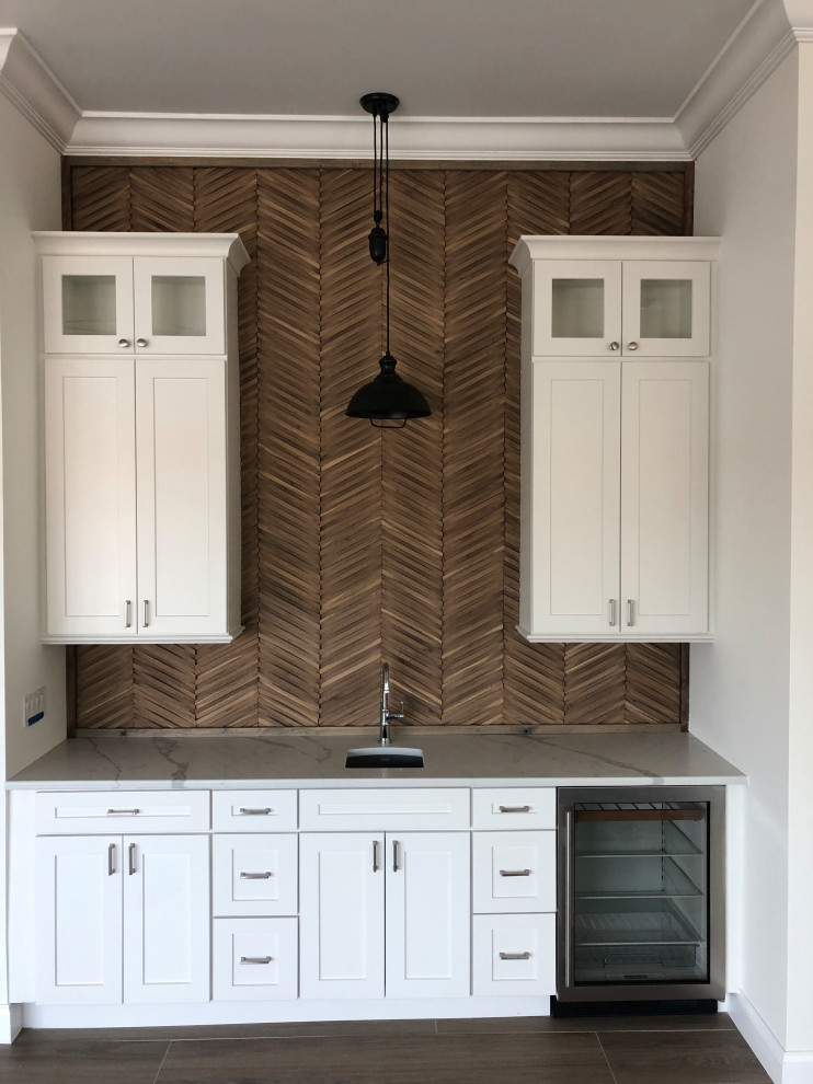 Mid-sized beach style single-wall ceramic tile wet bar photo in Tampa with an undermount sink, shaker cabinets, white cabinets, quartzite countertops, brown backsplash, wood backsplash and white countertops