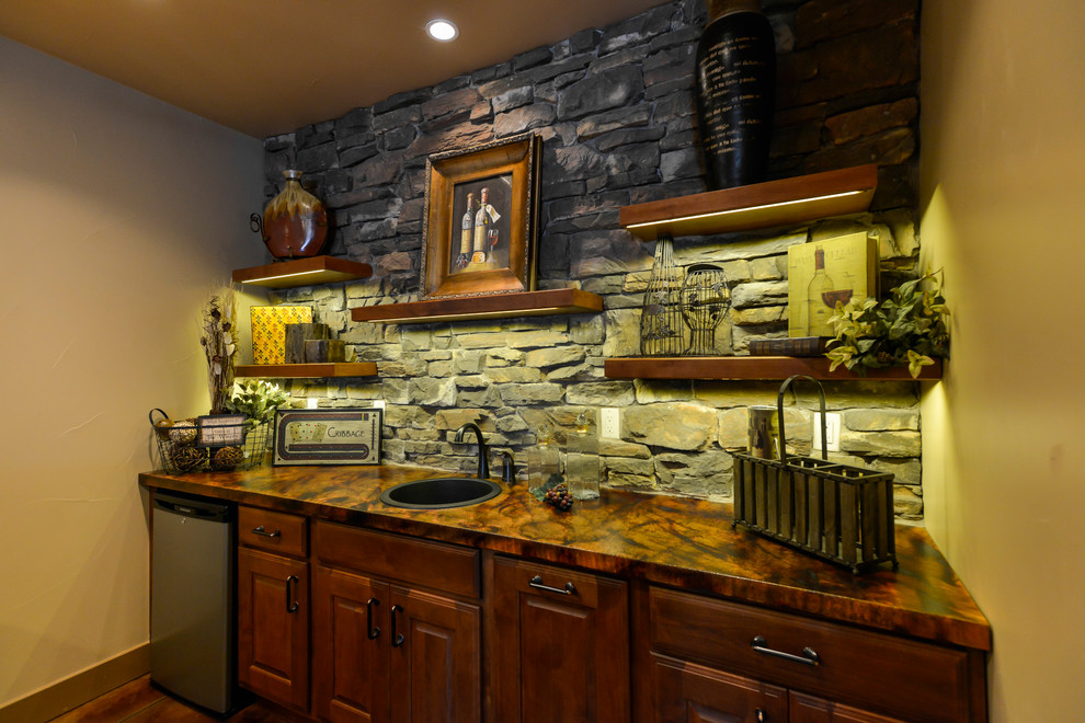 Photo of a medium sized rustic galley breakfast bar in Denver with a built-in sink, raised-panel cabinets, dark wood cabinets, copper worktops, multi-coloured splashback, stone tiled splashback, concrete flooring and brown floors.