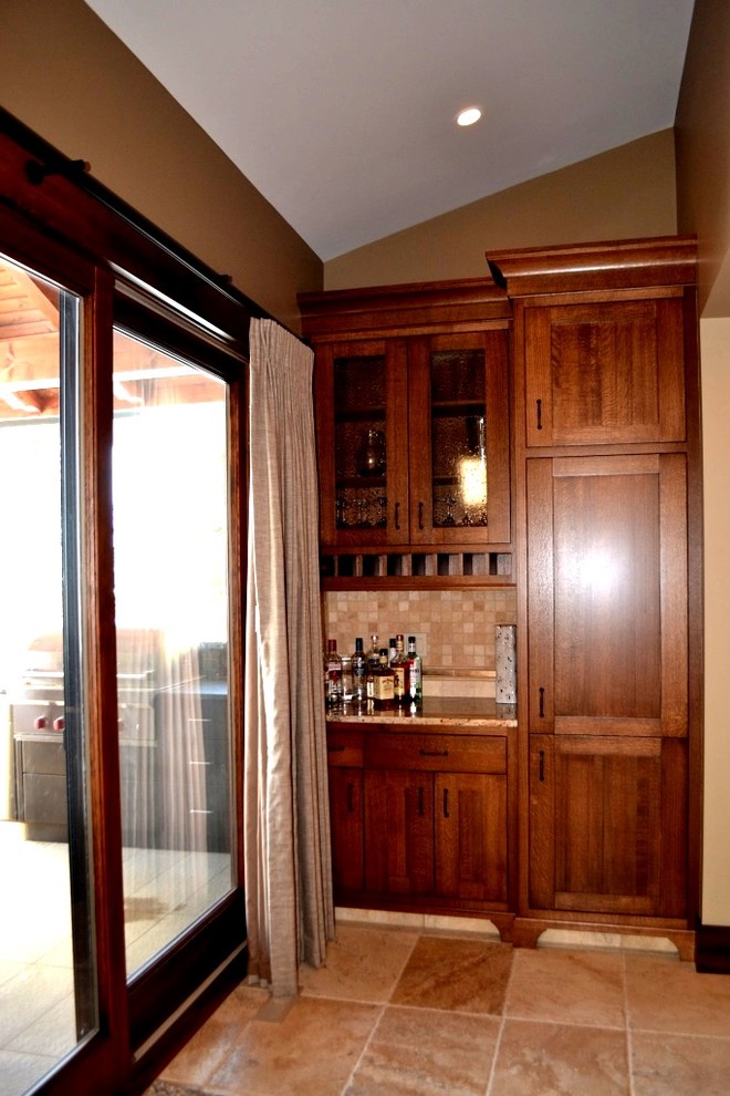 Foto på en liten amerikansk linjär hemmabar med vask, med luckor med infälld panel, skåp i mörkt trä, granitbänkskiva, beige stänkskydd, stänkskydd i stenkakel, travertin golv och beiget golv