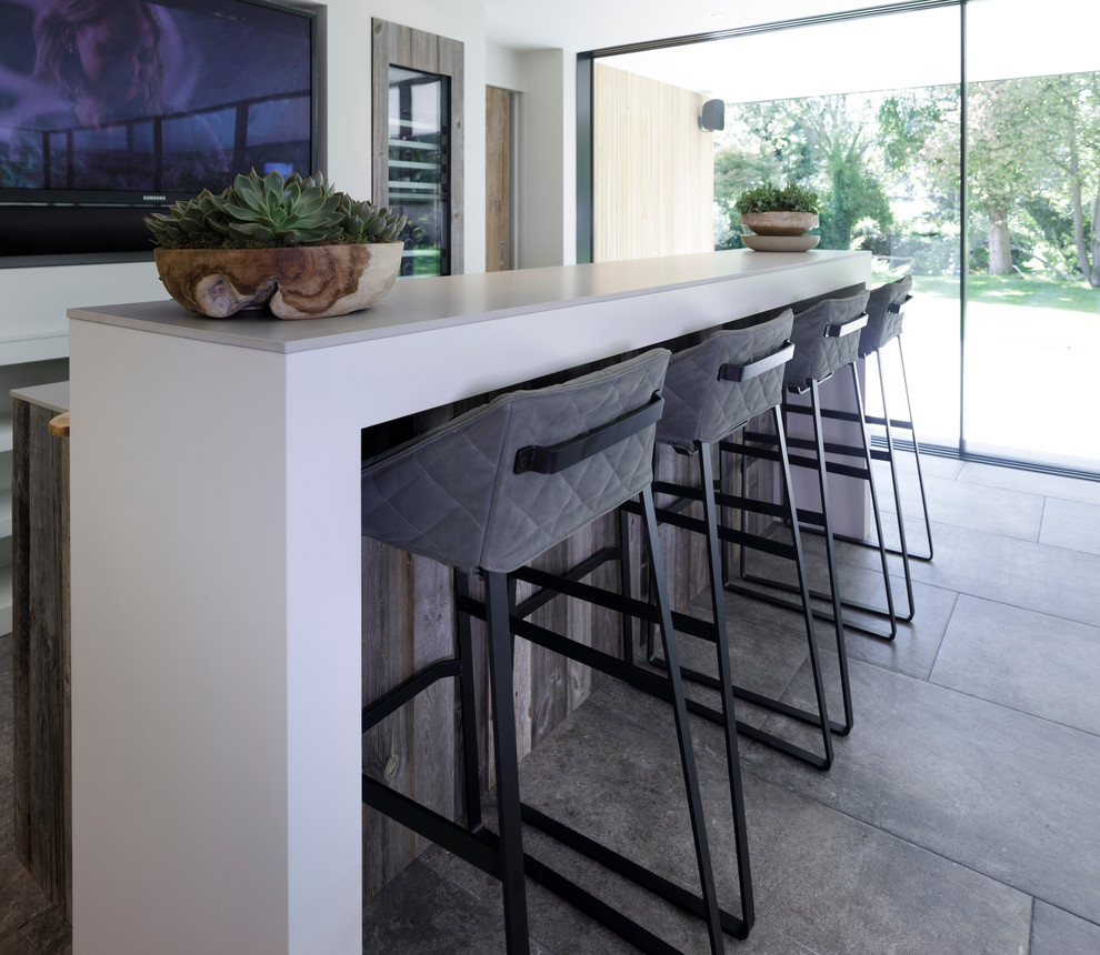 Inspiration for a medium sized contemporary galley wet bar in Cheshire with a built-in sink, flat-panel cabinets, medium wood cabinets, concrete worktops, white splashback, ceramic splashback, ceramic flooring and grey floors.