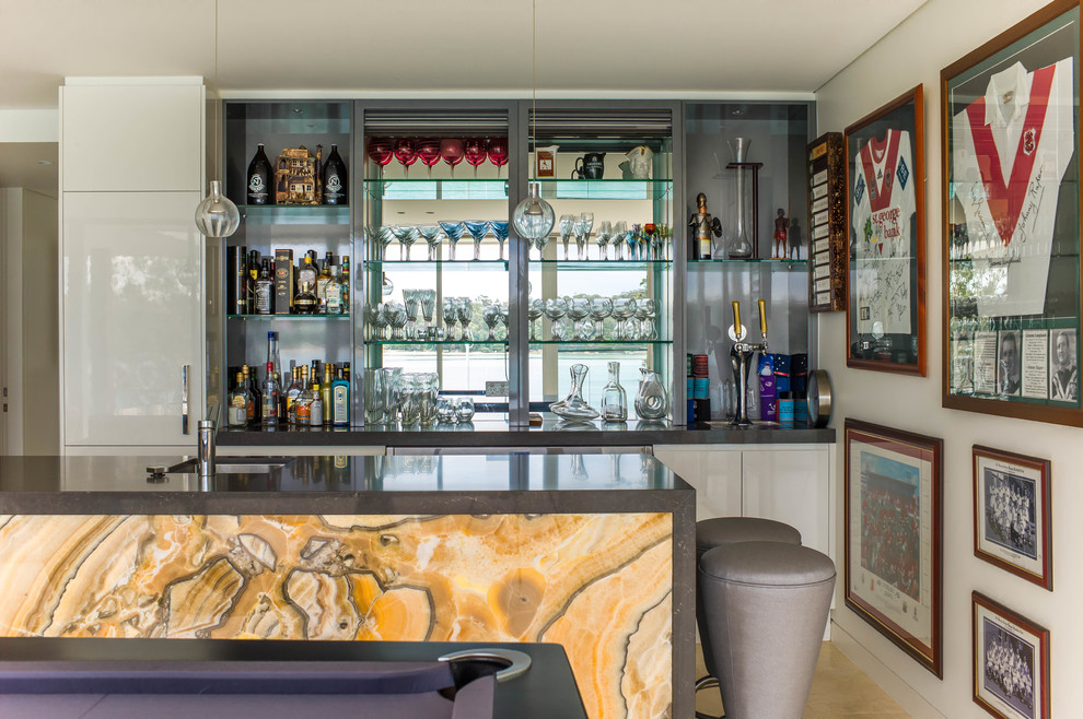 Idée de décoration pour un bar de salon avec évier parallèle design avec un évier encastré, un placard à porte plane, des portes de placard blanches et un sol beige.