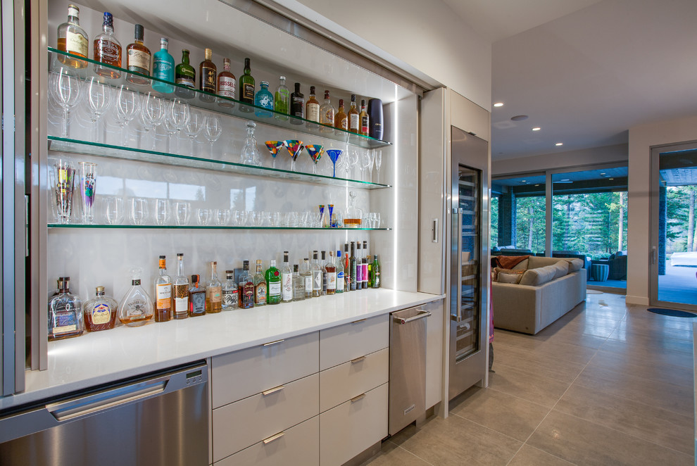 Inspiration for a contemporary single-wall home bar in Vancouver with flat-panel cabinets, grey cabinets, white splashback and beige floors.