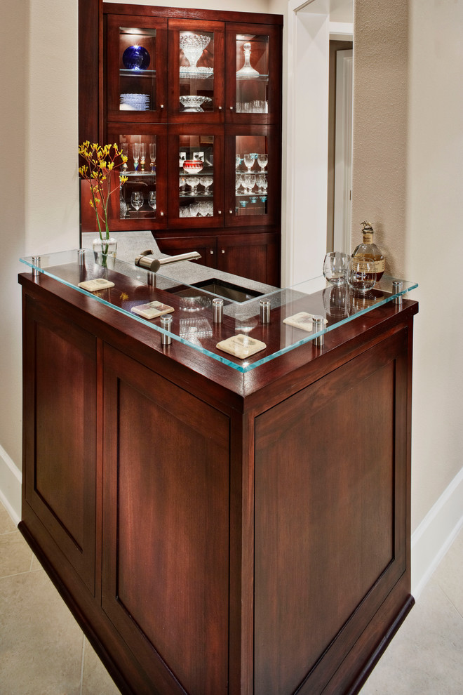 This is an example of a small contemporary single-wall wet bar in Austin with a submerged sink, glass-front cabinets and dark wood cabinets.