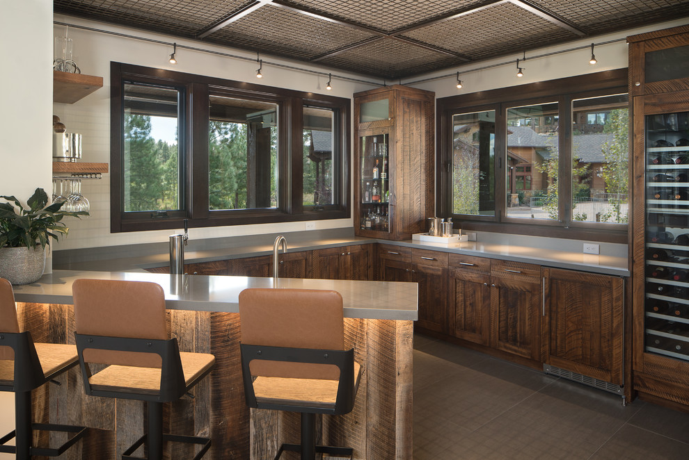 Idee per un bancone bar rustico con ante in stile shaker, ante in legno bruno, pavimento marrone e top grigio