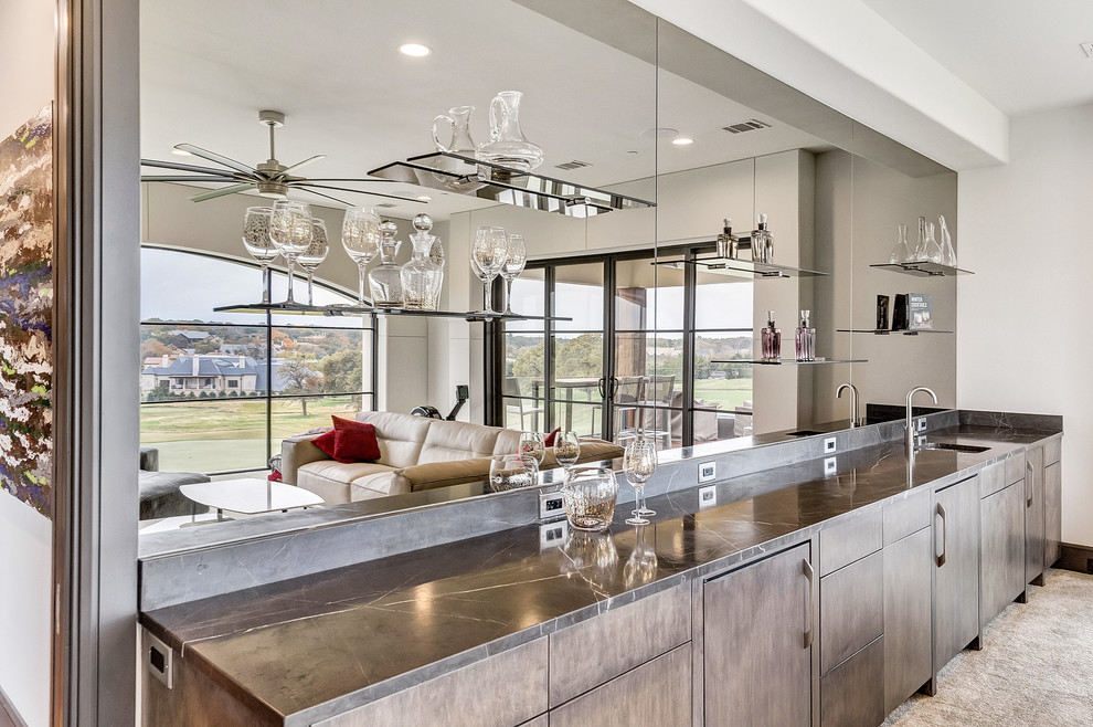 This is an example of a medium sized contemporary single-wall wet bar in Orange County with a submerged sink, flat-panel cabinets, medium wood cabinets, marble worktops, mirror splashback, carpet and beige floors.