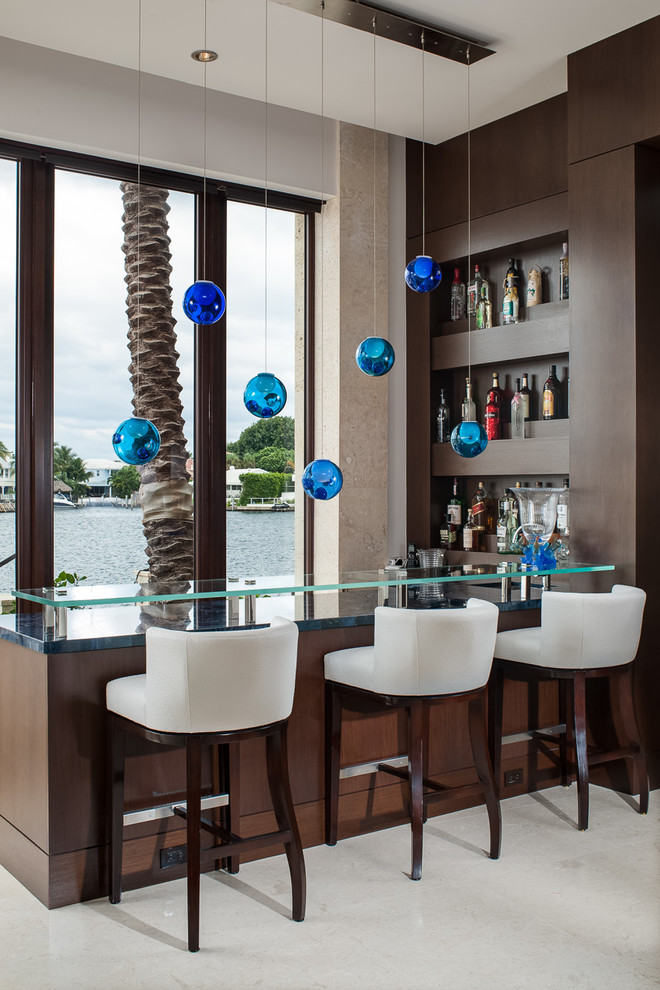 Trendy l-shaped seated home bar photo in Miami with dark wood cabinets, glass countertops and blue countertops