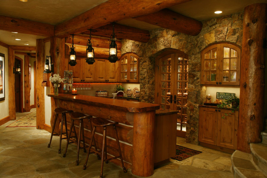 Ispirazione per un grande bancone bar rustico con ante con bugna sagomata, ante in legno scuro, top in legno e pavimento in cemento