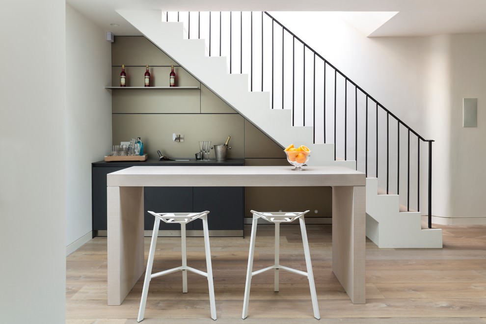 Inspiration for a contemporary galley medium tone wood floor and beige floor wet bar remodel in Oxfordshire with an undermount sink, flat-panel cabinets and beige backsplash