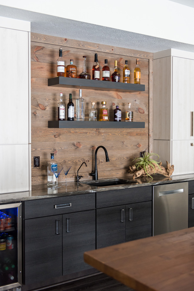 Wet bar - mid-sized transitional u-shaped medium tone wood floor wet bar idea in Indianapolis with an undermount sink, flat-panel cabinets, black cabinets and granite countertops