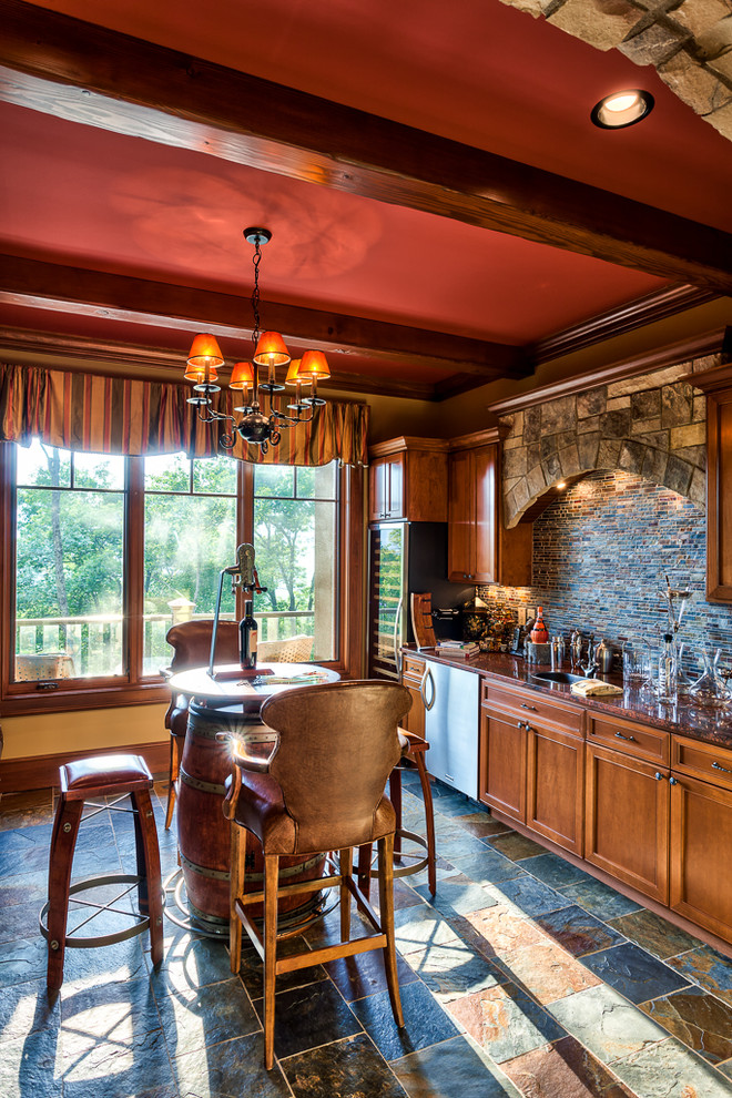 Elegant single-wall multicolored floor and slate floor seated home bar photo in Other with shaker cabinets, medium tone wood cabinets, multicolored backsplash and brown countertops