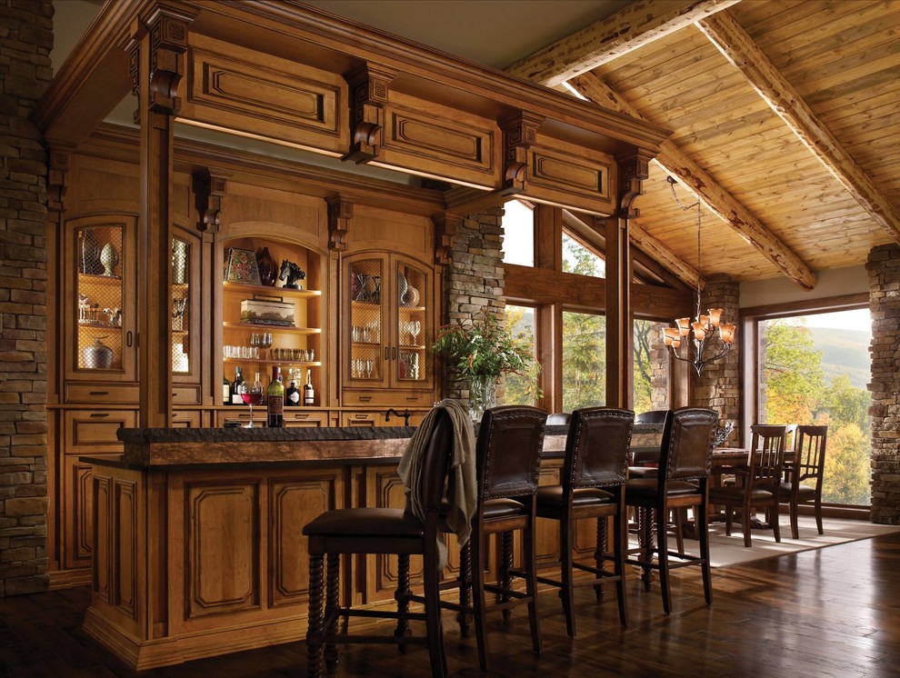 Immagine di un grande bancone bar stile rurale con lavello sottopiano, ante con riquadro incassato, top in superficie solida, pavimento in legno massello medio e ante in legno chiaro