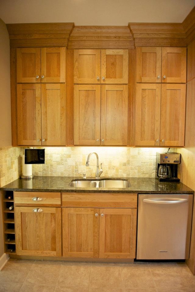 This is an example of a medium sized traditional single-wall wet bar in Chicago with a submerged sink, shaker cabinets, light wood cabinets, granite worktops, beige splashback, stone tiled splashback and travertine flooring.