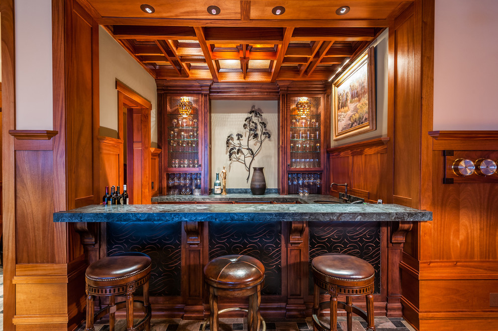 Idée de décoration pour un petit bar de salon parallèle craftsman en bois brun avec des tabourets, un placard à porte vitrée, un sol en bois brun, un sol marron et un plan de travail gris.