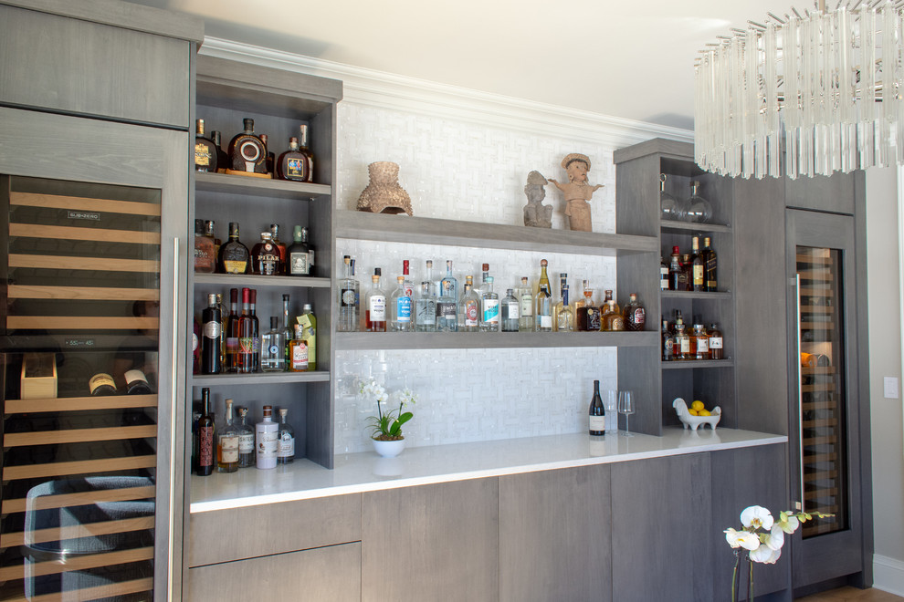 Photo of a medium sized contemporary single-wall home bar in Portland Maine with flat-panel cabinets, grey cabinets and engineered stone countertops.