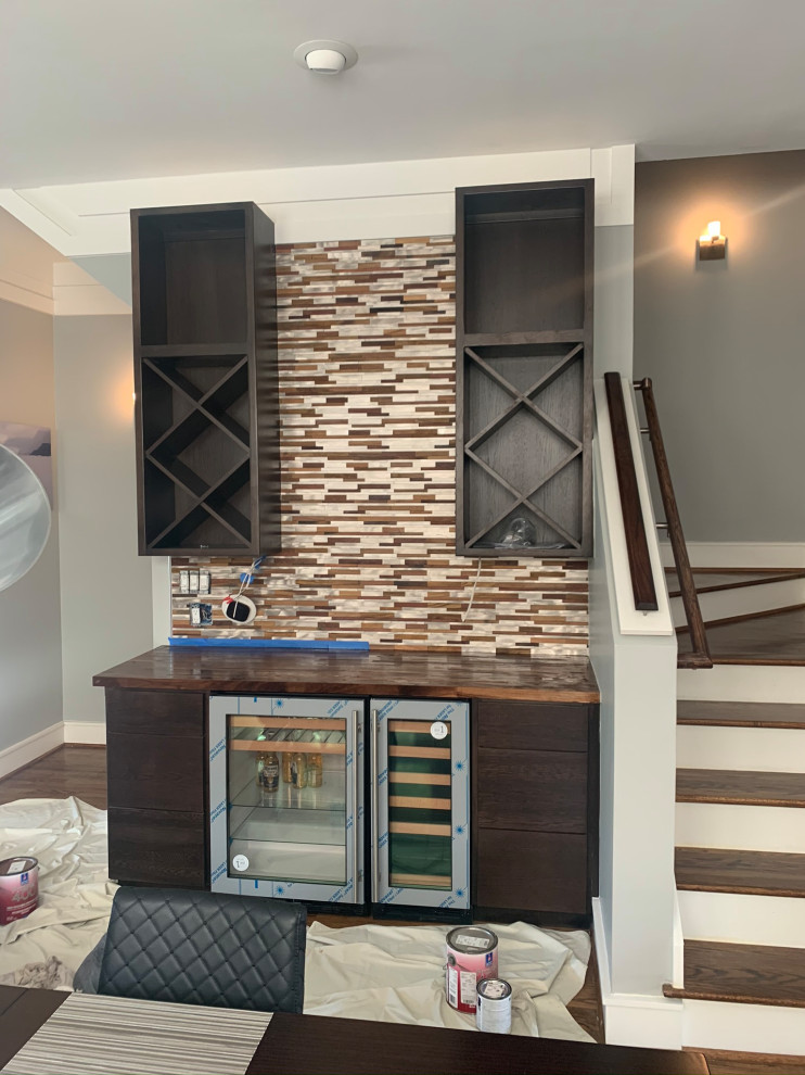 Medium sized modern single-wall wet bar in Houston with flat-panel cabinets, dark wood cabinets, wood worktops, multi-coloured splashback, metal splashback and brown worktops.
