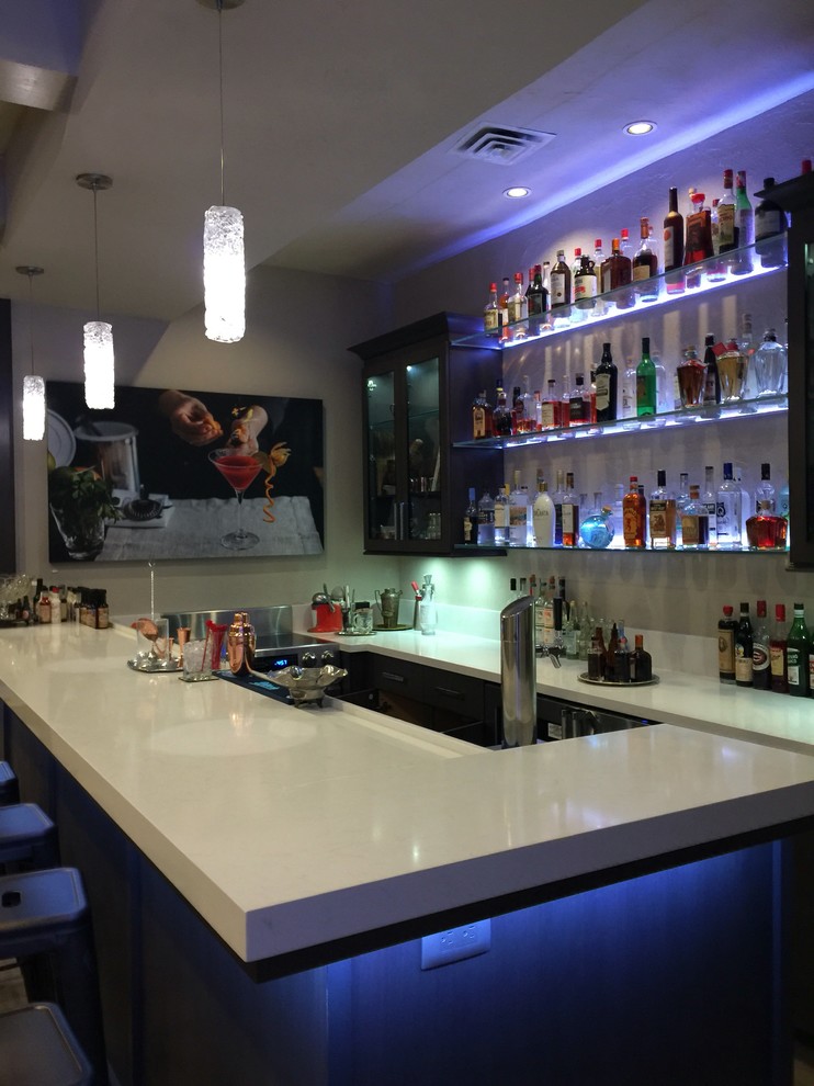 This is an example of a medium sized modern u-shaped breakfast bar in Miami with a built-in sink, glass-front cabinets, dark wood cabinets, marble worktops and light hardwood flooring.
