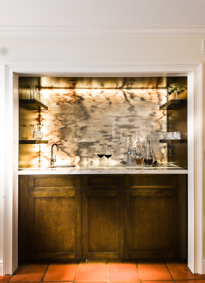 Photo of a medium sized contemporary galley wet bar in Miami with shaker cabinets, medium wood cabinets, marble worktops, grey splashback, stone slab splashback and terracotta flooring.
