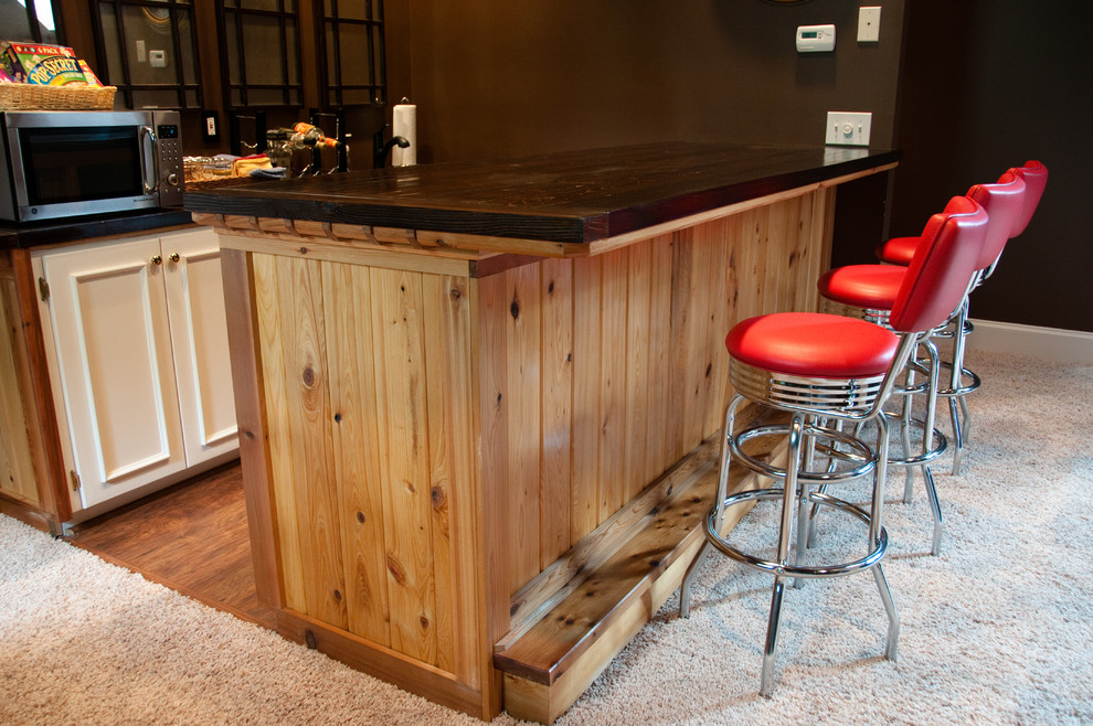 Ispirazione per un bancone bar stile rurale di medie dimensioni con top in legno, parquet chiaro, ante con riquadro incassato e ante beige