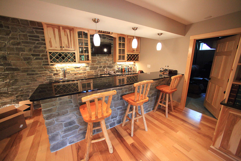 Photo of a medium sized rustic u-shaped breakfast bar in Philadelphia with a submerged sink, recessed-panel cabinets, distressed cabinets, composite countertops, multi-coloured splashback, stone slab splashback and light hardwood flooring.