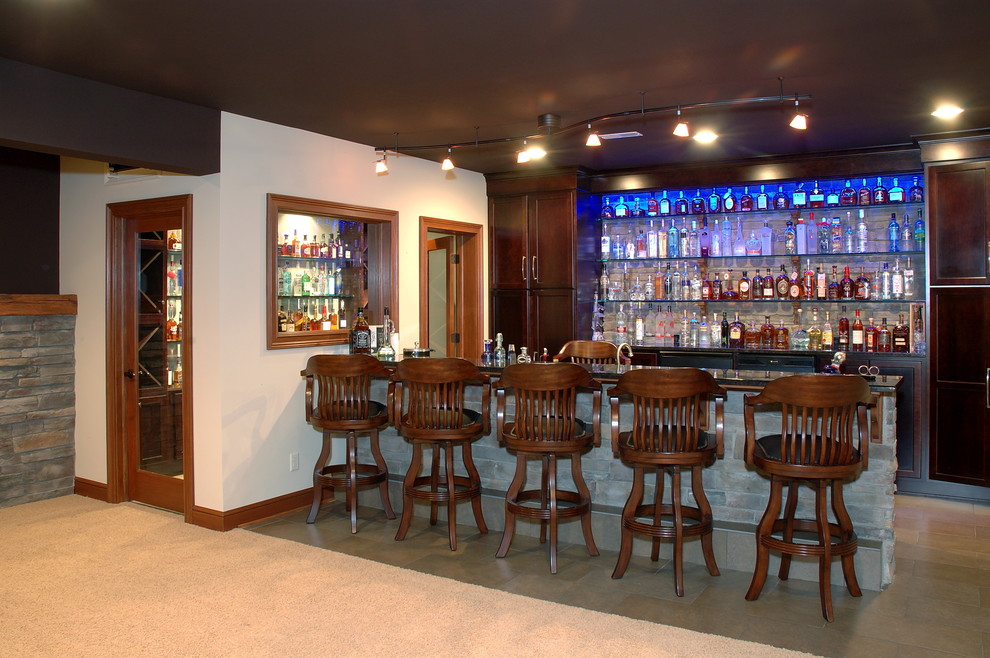 Aménagement d'un grand bar de salon parallèle classique en bois foncé avec des tabourets, un placard à porte shaker, sol en béton ciré et un sol gris.