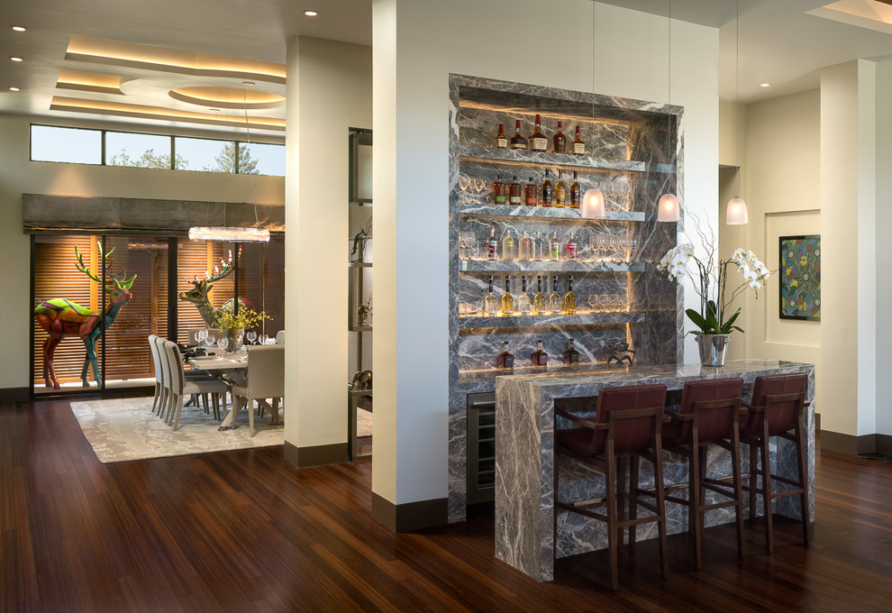 Inspiration for a mid-sized contemporary galley bamboo floor seated home bar remodel in San Francisco with no sink, flat-panel cabinets, gray cabinets, marble countertops, gray backsplash and stone slab backsplash