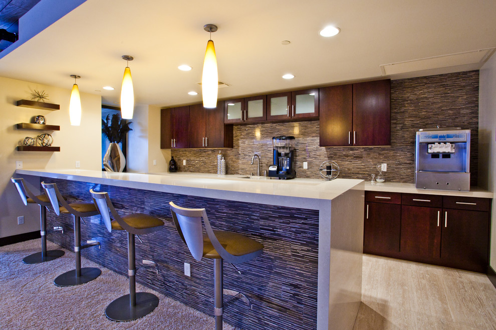 Photo of an expansive contemporary single-wall wet bar in Las Vegas with flat-panel cabinets, dark wood cabinets, multi-coloured splashback, matchstick tiled splashback, porcelain flooring, beige floors, beige worktops, a built-in sink and composite countertops.