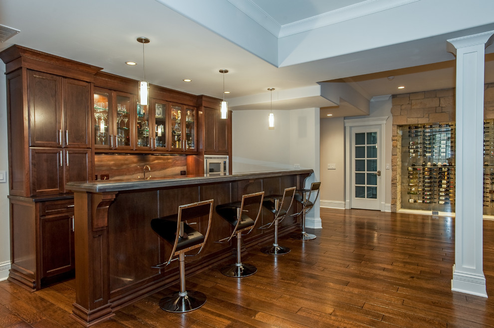 Design ideas for a traditional galley breakfast bar in Chicago with dark hardwood flooring, recessed-panel cabinets, dark wood cabinets, brown splashback and brown floors.