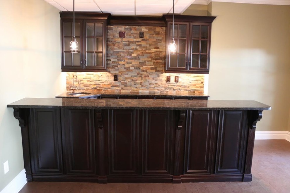 Seated home bar - traditional galley seated home bar idea in New York with dark wood cabinets and granite countertops