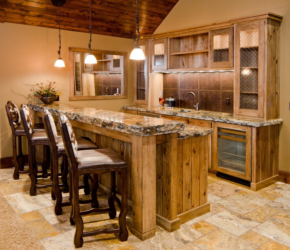 Example of a large classic galley travertine floor and beige floor seated home bar design in Other with an undermount sink, glass-front cabinets, medium tone wood cabinets, brown backsplash, granite countertops and brown countertops