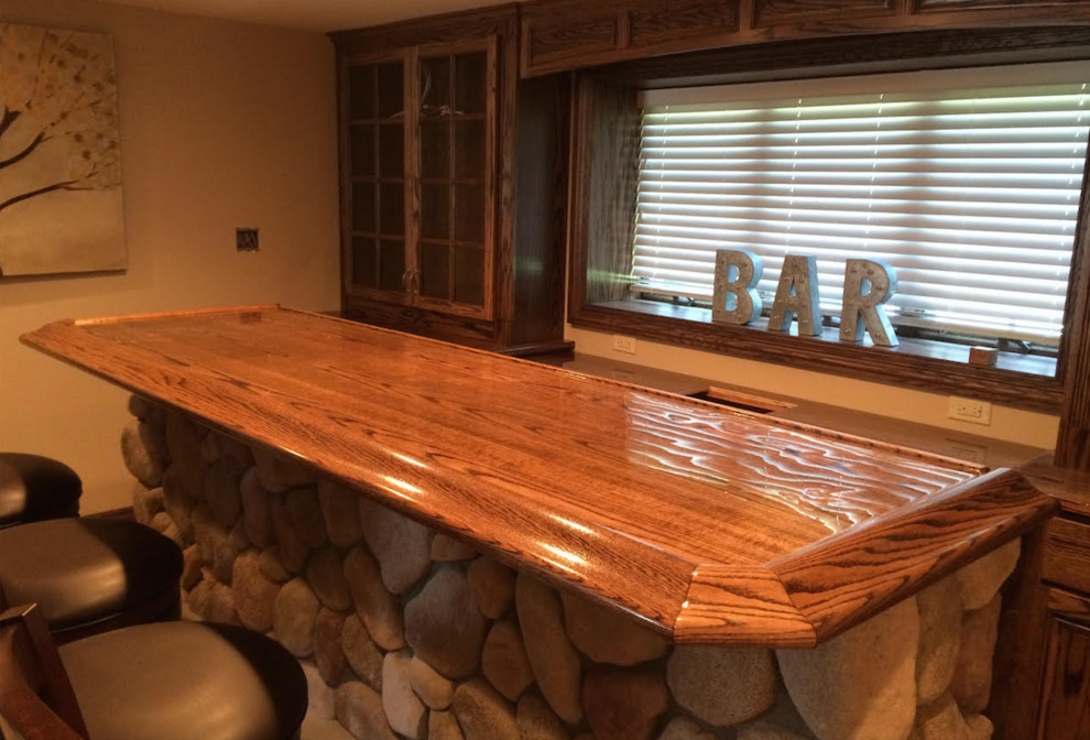 Cette image montre un grand bar de salon linéaire traditionnel en bois foncé avec des tabourets, un placard à porte vitrée, un plan de travail en bois et un sol en carrelage de céramique.