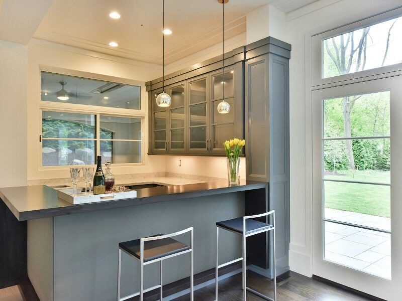 Photo of a medium sized traditional u-shaped breakfast bar in New York with glass-front cabinets, grey cabinets, marble worktops, dark hardwood flooring and brown floors.