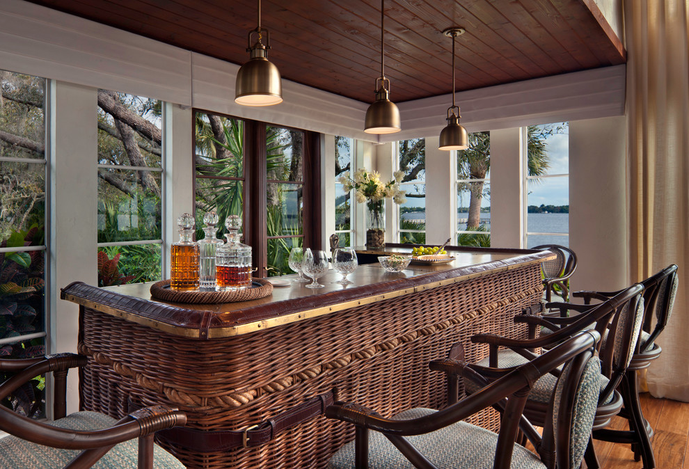 Ispirazione per un bancone bar tropicale di medie dimensioni con pavimento in legno massello medio e pavimento marrone