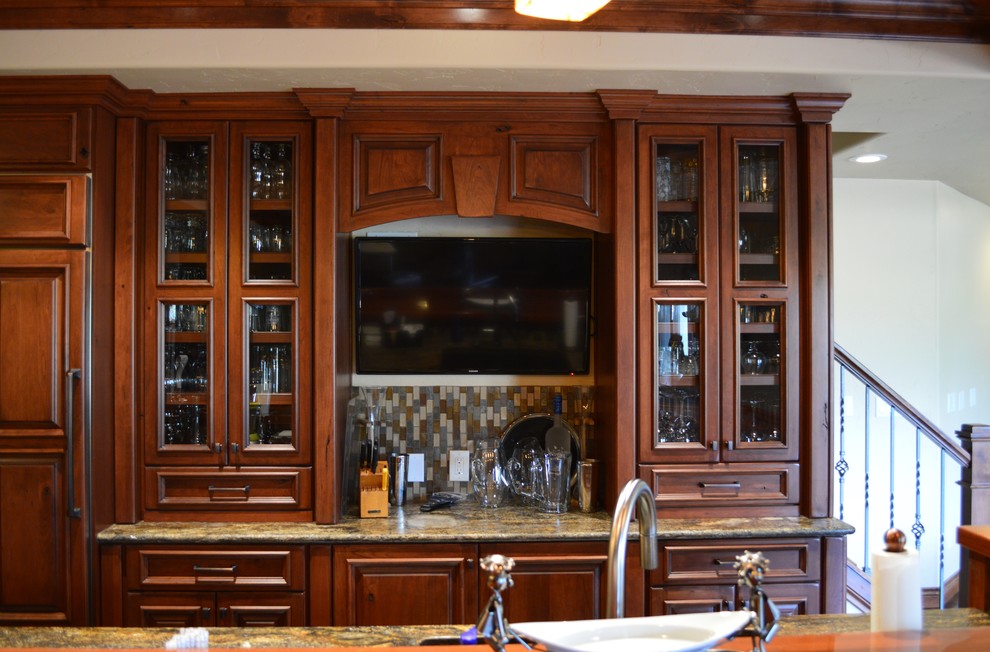 Ejemplo de bar en casa con fregadero en L tradicional grande con puertas de armario de madera oscura