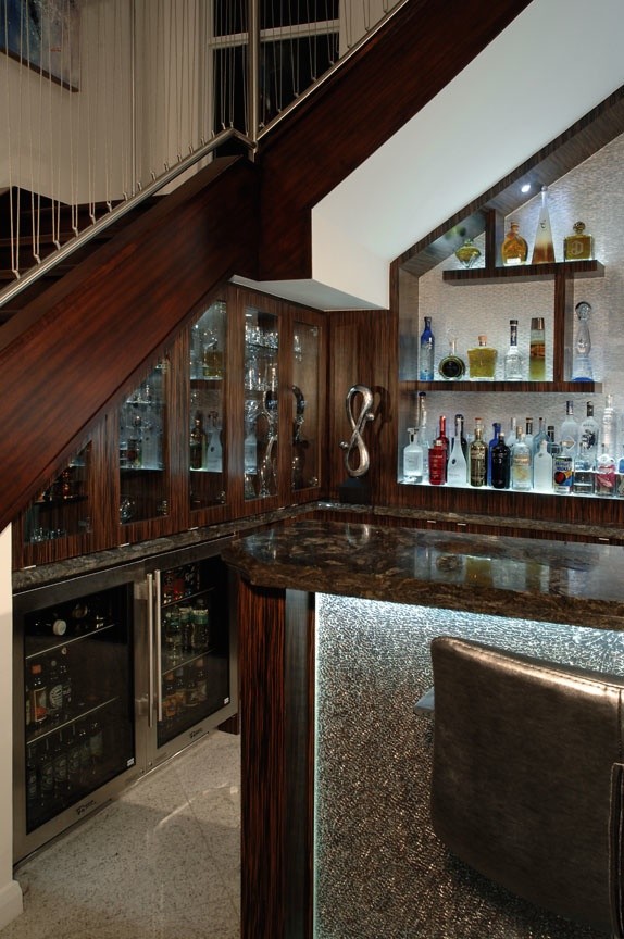 Источник вдохновения для домашнего уюта: п-образный домашний бар в стиле модернизм с барной стойкой, врезной мойкой, стеклянными фасадами, темными деревянными фасадами, гранитной столешницей и серым фартуком
