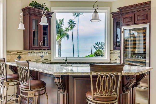 Medium sized classic u-shaped breakfast bar in San Diego with glass-front cabinets, dark wood cabinets, multi-coloured splashback and marble flooring.