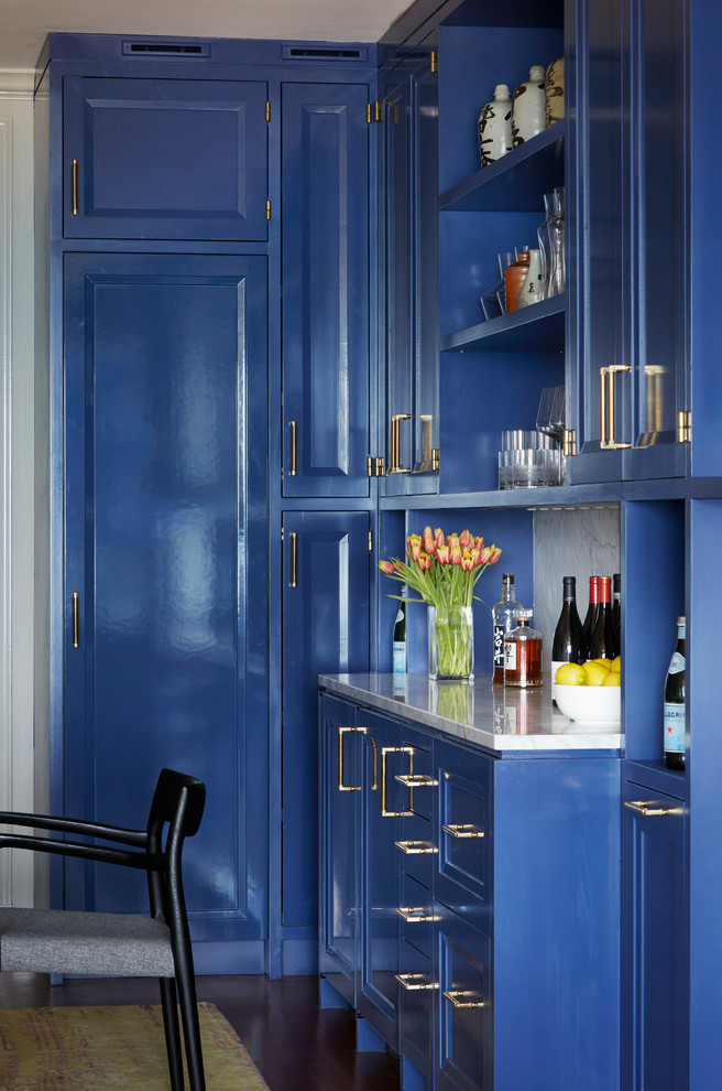 Idee per un piccolo angolo bar tradizionale con ante in stile shaker, ante blu, top in marmo, paraspruzzi bianco e paraspruzzi in marmo