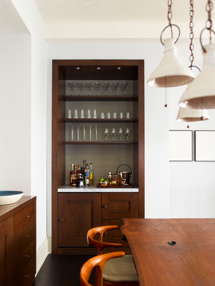 This is an example of a traditional home bar in New York with dark hardwood flooring.