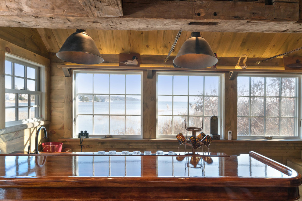Cette image montre un bar de salon chalet en bois brun avec des tabourets, un plan de travail en bois et un plan de travail marron.